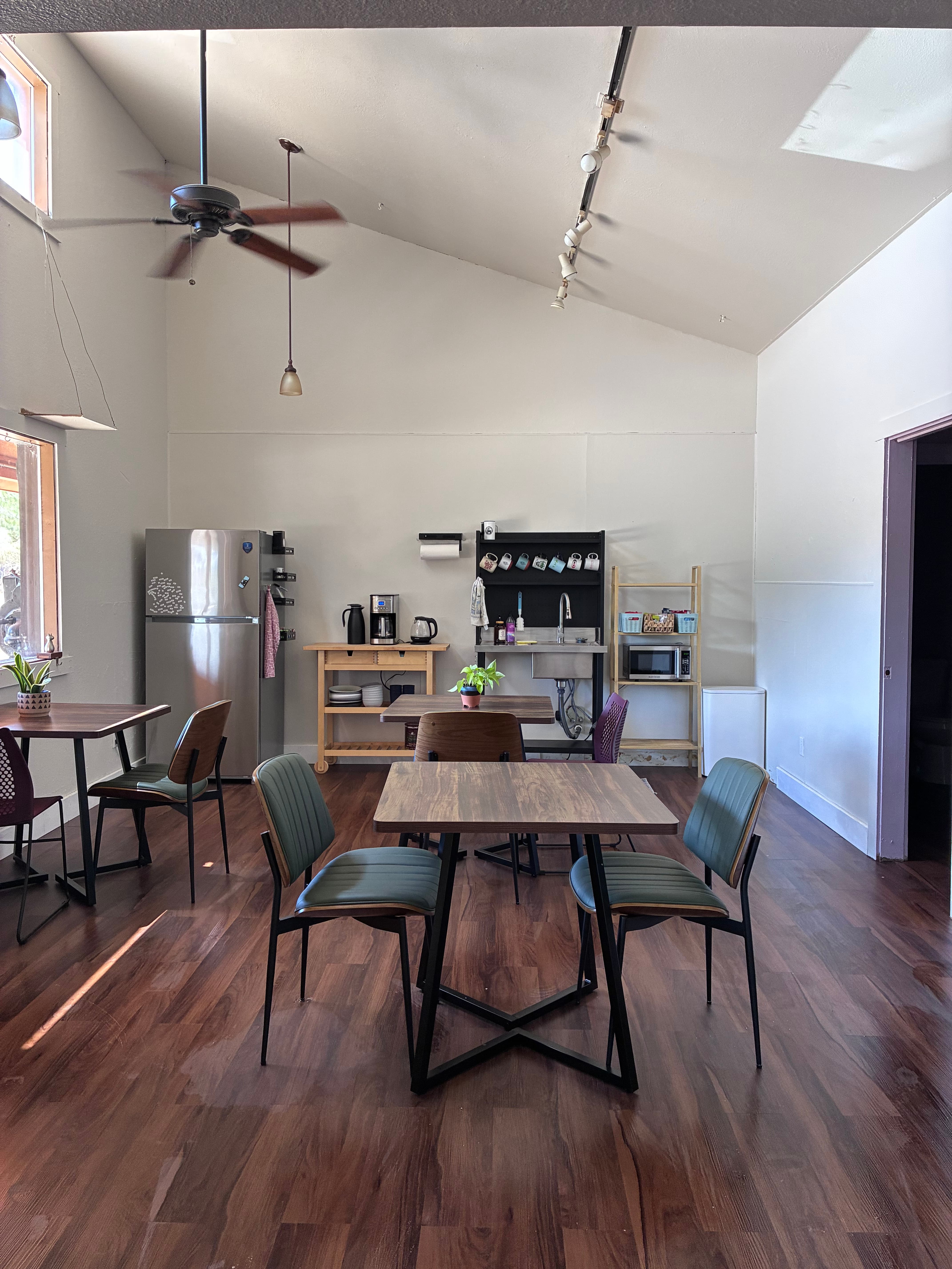 Communal kitchen and cafe seating with coffee station and refrigerator